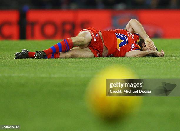 Jason Akermanis of the All Stars lays on the ground after sustaining an injury in a contest during the EJ Whitten Legends match at Etihad Stadium on...