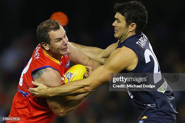 Chris Tarrant of Victoria tackles Wayne Carey of the All Stars during the EJ Whitten Legends match at Etihad Stadium on September 2, 2016 in...