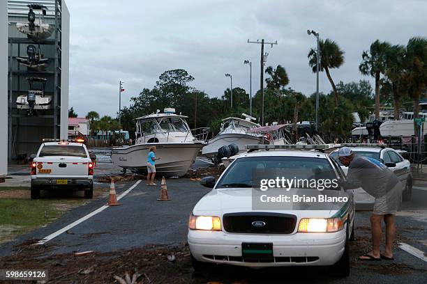 Residents survey damage from the winds and storm surge associated with Hurricane Hermine which made landfall overnight in the area on September 2,...