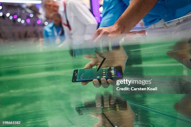 Visitor tests the waterproof S7 from Samsung at the 2016 IFA consumer electronics trade fair on September 2, 2016 in Berlin, Germany. IFA is among...