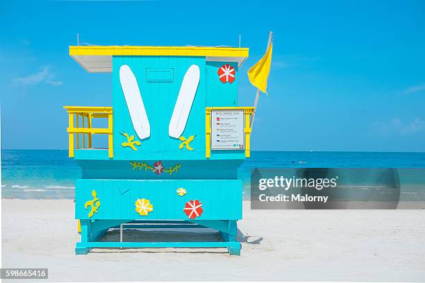 usa, florida, miami beach. lifeguard tower on beach with yellow flag - cabina del guardaspiaggia foto e immagini stock