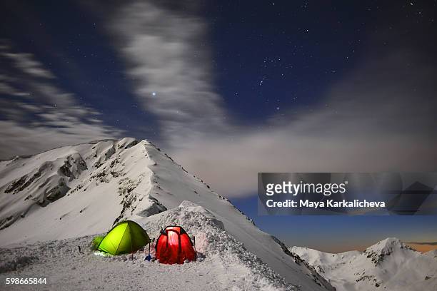 nighttime tents in the snow - snow shovel stock-fotos und bilder