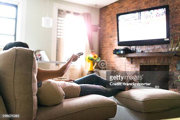woman relaxing online on sofa reading some papers - feet up 個照片及圖片檔