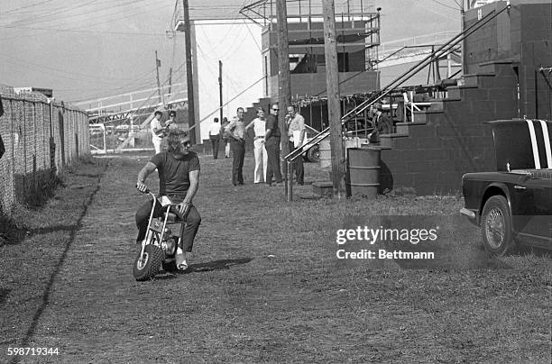 Driver Steve McQueen gets the pit crews laughing as he spins around on a mini-bike with his leg in a cast. The Los Angeles based driver broke his...