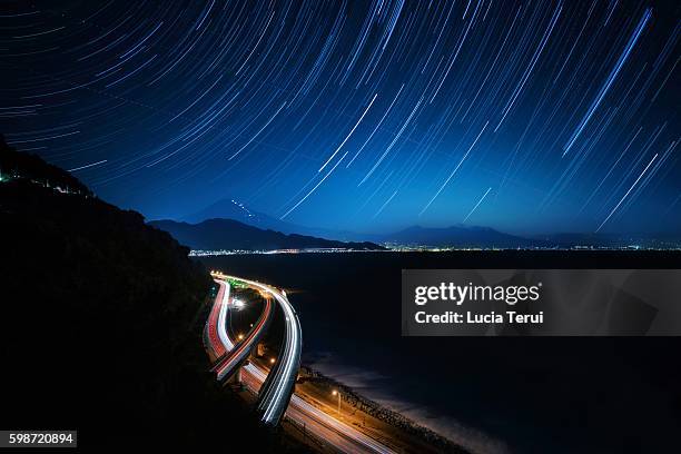 star trails in tomei expressway and light lines of mt. fuji climbers. - star sky stock-fotos und bilder