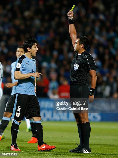 Referee Julio Bascuñán shows a yellow card to Jorge Fucile of Uruguay during a match between Argentina and Uruguay as part of FIFA 2018 World Cup...