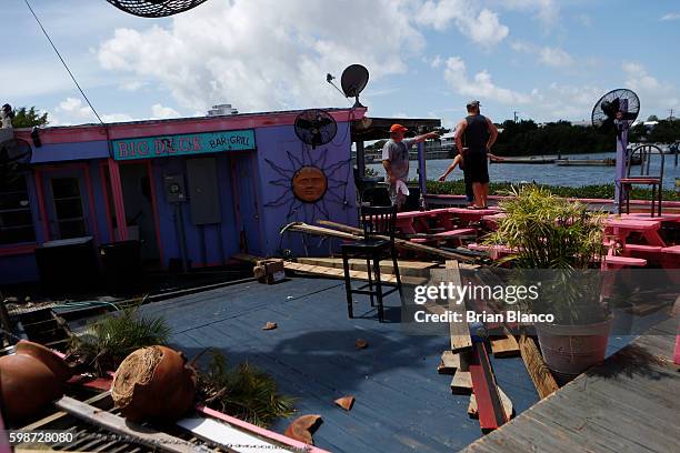 Residents survey damage at the Big Deck Bar & Grill left behind by the winds and storm surge associated with Hurricane Hermine which made landfall...