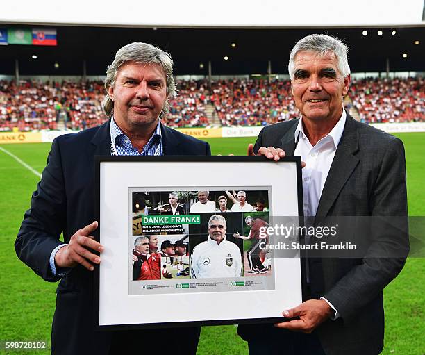 Frank Engel recieves an award in recognition of hius long service as a coach from Ronny Zimmermann during the Under21 friendly match between U21...