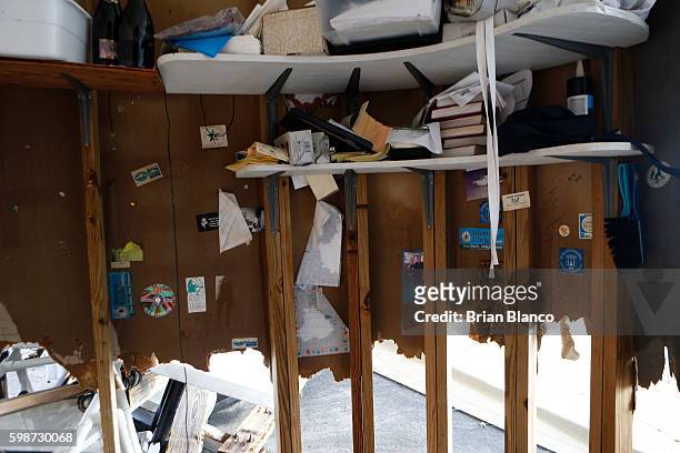 Photographs and books sit on what is left of the saltwater-soaked drywall inside the bar office area of the Cedar Cove resort after being damaged by...