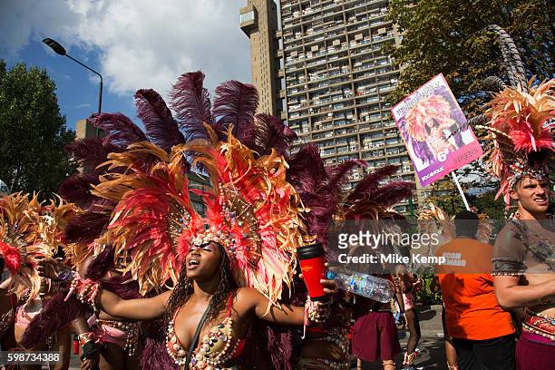 Parade dancers in feather costumes stop in the street at the base of Trellick Tower on Monday 28th August 2016 at the 50th Notting Hill Carnival in...
