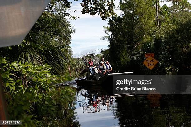 Law enforcement officers use an airboat to survey damage around homes from high winds and storm surge associated with Hurricane Hermine which made...