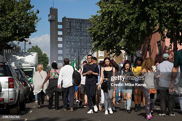 Group of friends walk along Golborne Road with Trellick Tower in the distance on Monday 28th August 2016 at the 50th Notting Hill Carnival in West...