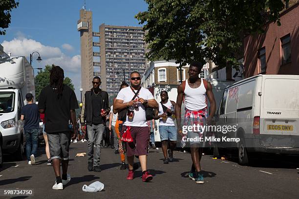 Group of friends walk along Golborne Road with Trellick Tower in the distance on Monday 28th August 2016 at the 50th Notting Hill Carnival in West...