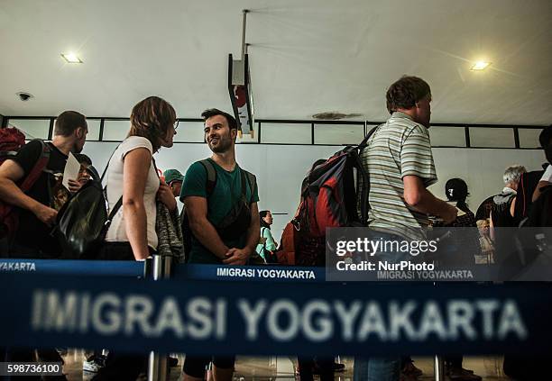 Some passenger from Singapore check passport after check body temperature with thermometer infrared by security health worker airport in Adi Sucipto...