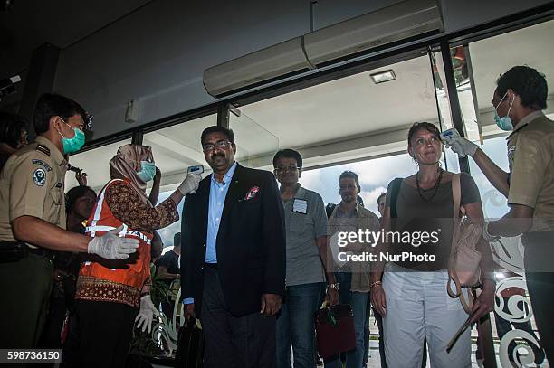 Some passenger from Singapore check body temperature with thermometer infrared by security health worker airport in Adi Sucipto International...