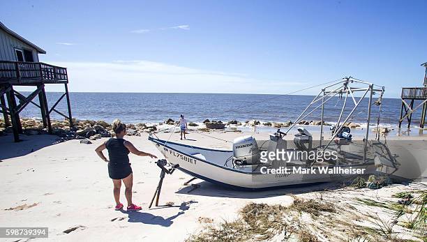 Cindy Figuroa points out the trailer to her boat buried in the sand pushed up during the storm surge from Hurricane Hermine at Alligator Point,...