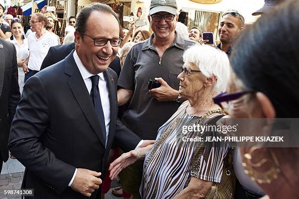 French President Francois Hollande shares a laught with people in Evian, French Alps, on September 2, 2016. / AFP / JEAN-PHILIPPE KSIAZEK