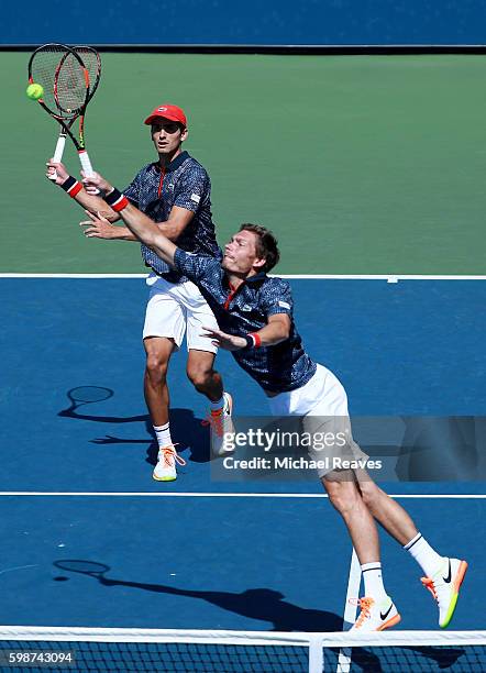 Nicolas Mahut reaches for a shot with partner Pierre-Hugues Herbert against Robin Haase of Netherlands and Artem Sitak of New Zealand on Day Five of...