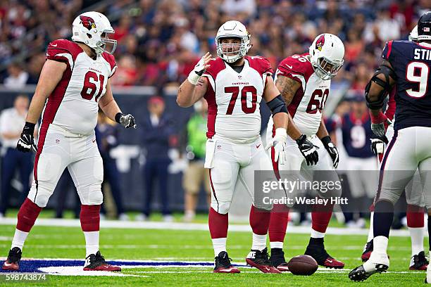 Evan Boehm of the Arizona Cardinals signals to Cole Toner during a preseason game against the Houston Texans at NRG Stadium on August 28, 2016 in...