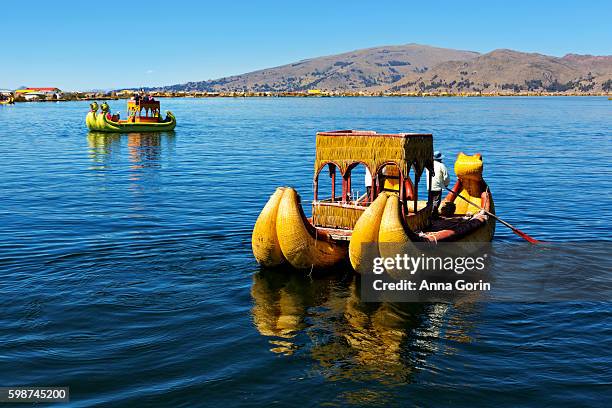 totora raft offers tourists a boat ride on lake titicaca offshore of the "floating islands" in puno district of peru - peru stock pictures, royalty-free photos & images
