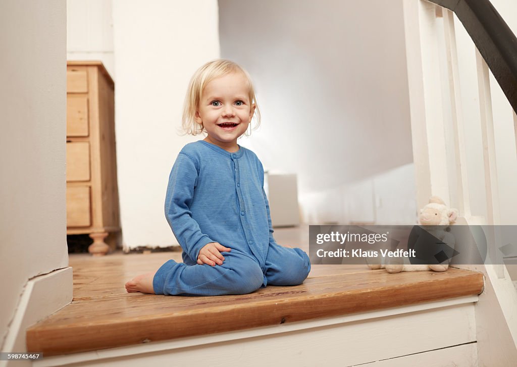 Happy child sitting on top of staircase