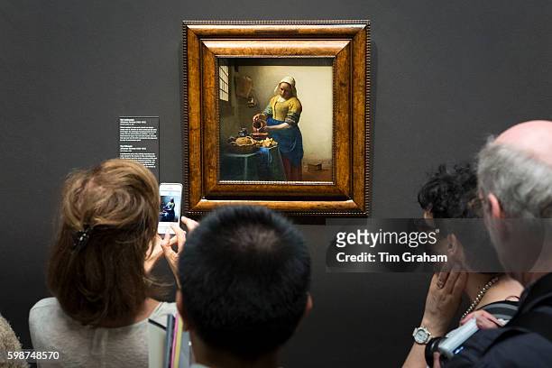Taking iPhone smartphone photograph of painting by Johannes Vermeer 'The Milkmaid' at Rijksmuseum, Amsterdam. , Holland.