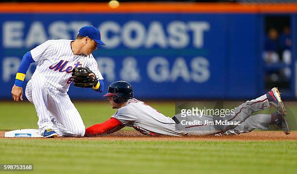 Trea Turner of the Washington Nationals steals second base in the first inning ahead of the tag from Kelly Johnson of the New York Mets at Citi Field...