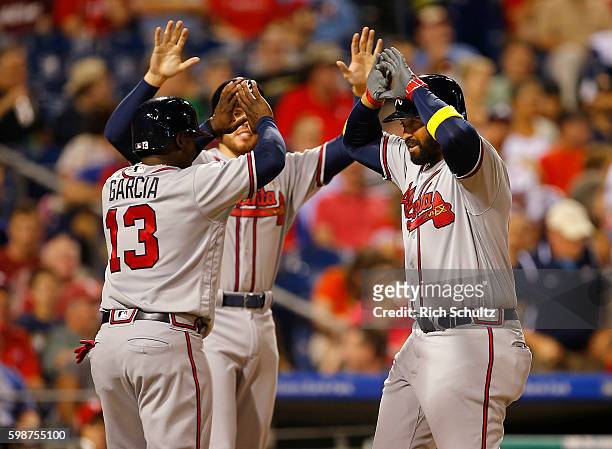 Matt Kemp of the Atlanta Braves is congratulated by Adonis Garcia and Freddie Freeman after he hit a three run home run against the Philadelphia...