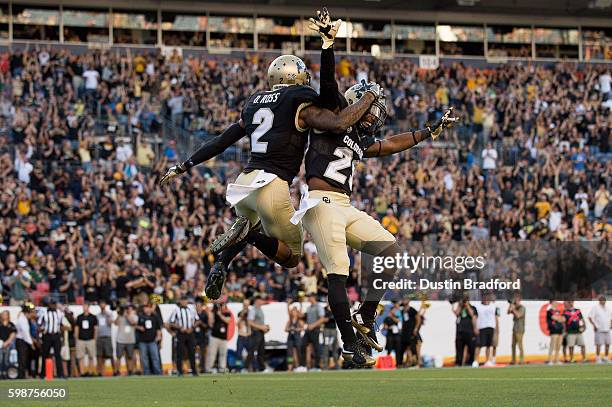 Wide receiver Devin Ross of the Colorado Buffaloes celebrates with running back Donovan Lee after scoring a first quarter touchdown against the...