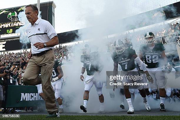Head coach Mark Dantonio of the Michigan State Spartans takes the field with his team prior to a game against the Furman Paladins at Spartan Stadium...