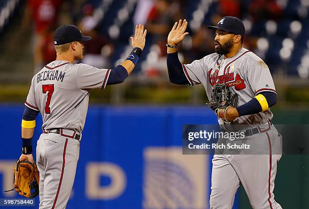 Gordon Beckham high fives teammate Matt Kemp of the Atlanta Braves after defeating the Philadelphia Phillies 8-4 during a game at Citizens Bank Park...