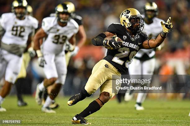 Running back Donovan Lee of the Colorado Buffaloes rushes for a second half first down against the Colorado State Rams at Sports Authority Field at...