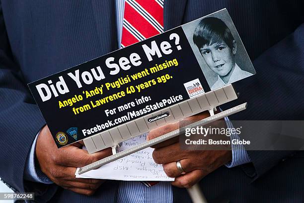 Lawrence Mayor Dan Rivera holds a sign of Angelo "Andy" Puglisi at a press conference to commemorate the passage of 40 years since the abduction of...