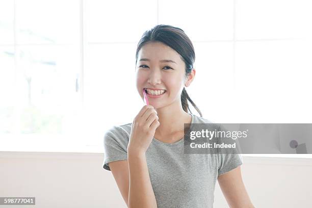 young woman brushing teeth - japanese brush stroke stock pictures, royalty-free photos & images