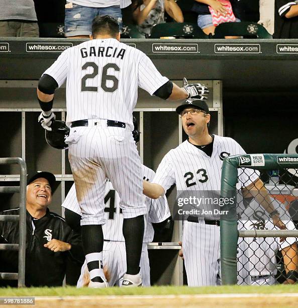 Avisail Garcia of the Chicago White Sox is congratulated by manager Robin Ventura and bench coach Rick Renteria after hitting a two run home run...