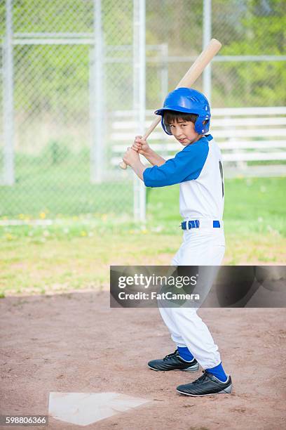 young boy up al bate - baseball cleats fotografías e imágenes de stock