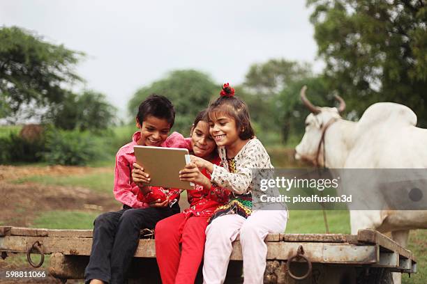 group of children using digital tablet - india poverty stock pictures, royalty-free photos & images