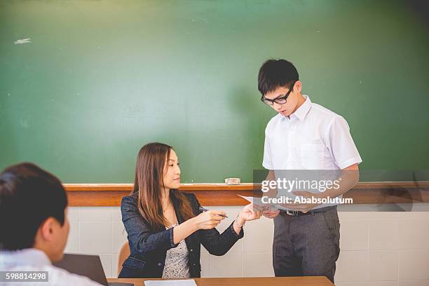 männliche studentin erhält prüfungsergebnisse, hongkong, china, asien - lypsehk2014 stock-fotos und bilder