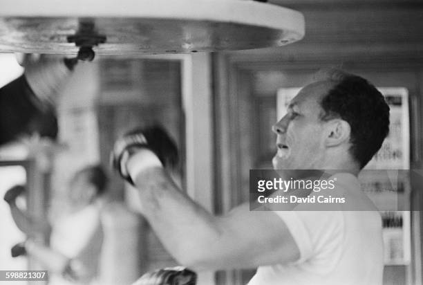 English heavyweight boxer Henry Cooper training at the Thomas a Becket gymnasium on the Old Kent Road, for his upcoming fight with Billy Walker,...