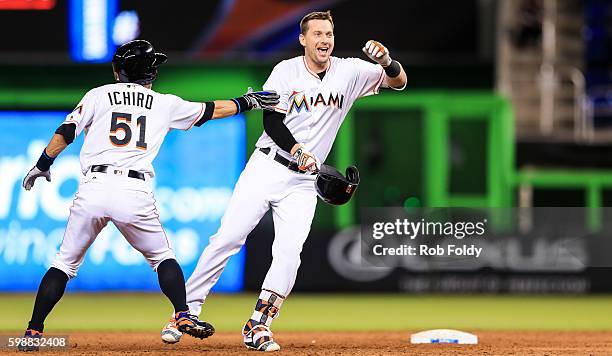 Chris Johnson of the Miami Marlins celebrates with Ichiro Suzuki after hitting a walk-off double to end the game against the San Diego Padres at...