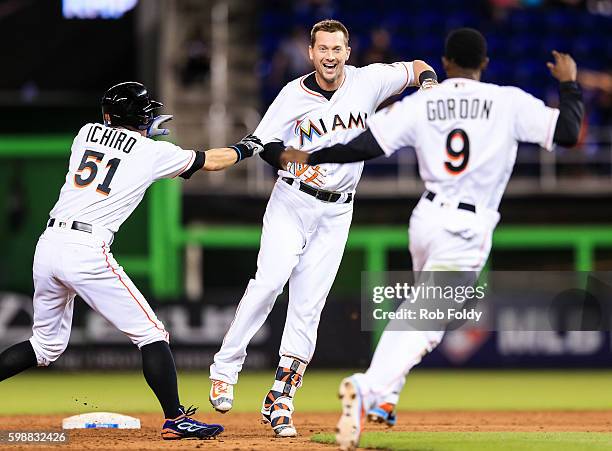 Chris Johnson of the Miami Marlins celebrates with Ichiro Suzuki and Dee Gordon after hitting a walk-off double to end the game against the San Diego...