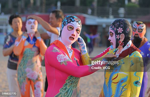 Women wearing siamesed facekinis play on beach on August 29, 2016 in Qingdao, Shandong Province of China. Facekini has been China\'s popular beach...