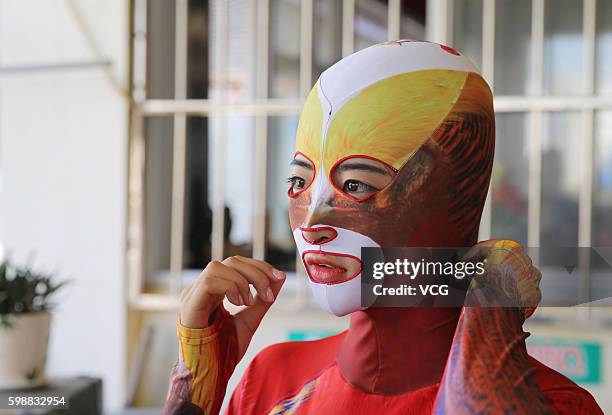 Woman adjusts her siamesed facekinis on August 28, 2016 in Qingdao, Shandong Province of China. Facekini has been China\'s popular beach trend and...