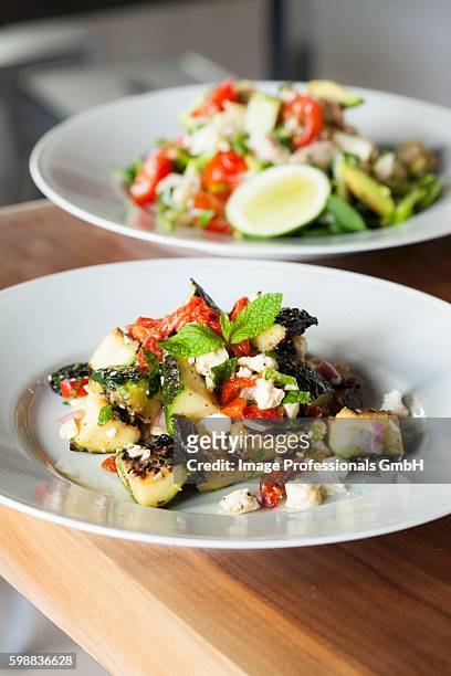 mediterranean zucchini salad with red peppers, red onion and feta cheese; crab salad in background - fetta - fotografias e filmes do acervo