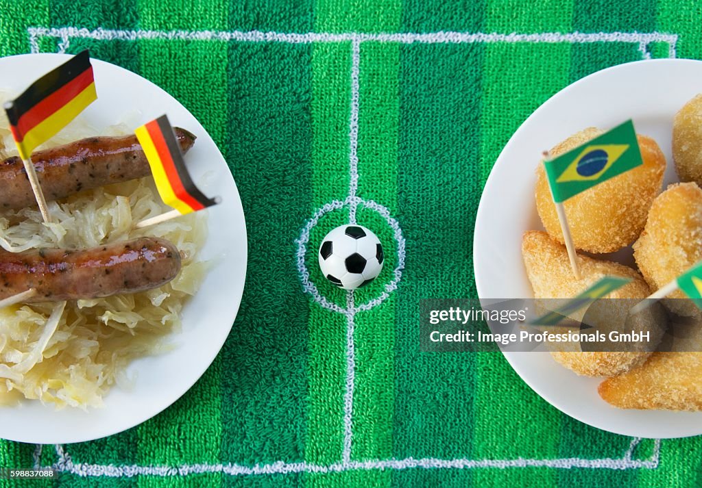 Sausages with cabbage (Germany) and salgadinhos (Brazil) with football-themed decoration