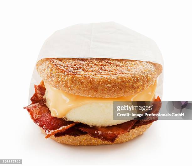 bacon egg and cheese breakfast sandwich on an english muffin; white background - muffin top stock-fotos und bilder
