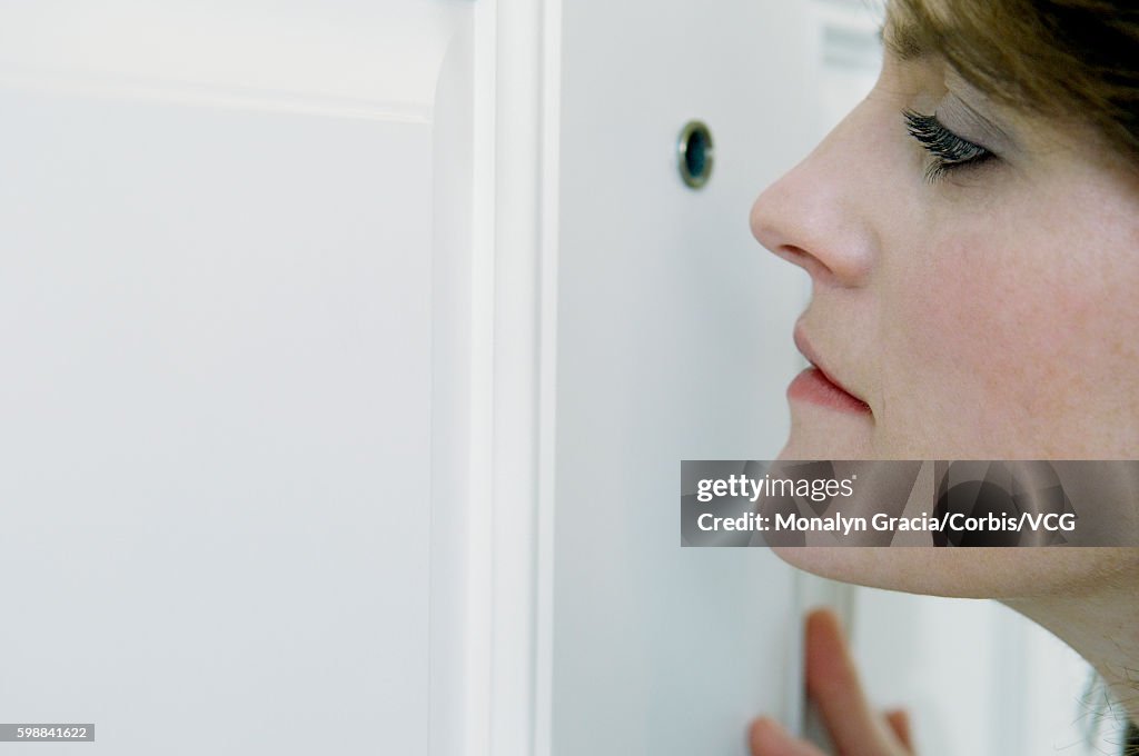 Woman looking through peephole
