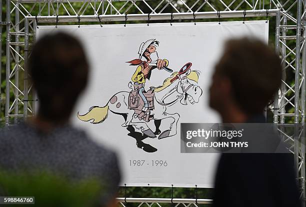 Quebec cartoonist Marc Delafontaine aka "Delaf" and screenwriter Maryse Dubuc, authors of the comic strip "Les nombrils", talk in front of Lucky Luke...