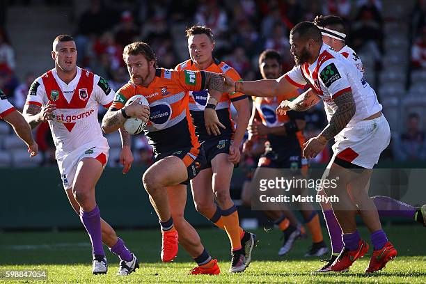 Korbin Sims of the Knights is tackled during the round 26 NRL match between the St George Illawarra Dragons and the Newcastle Knights at WIN Jubilee...