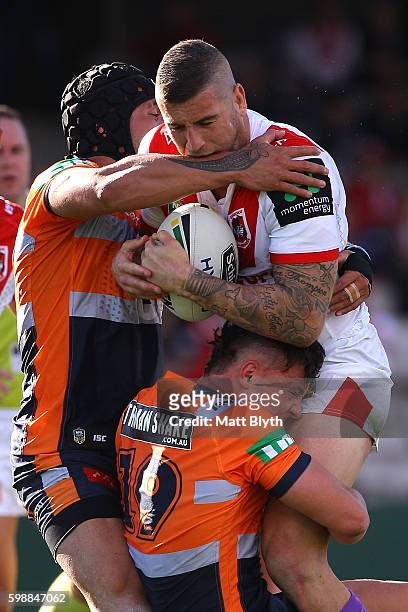 Joel Thompson of the Dragons is tackled during the round 26 NRL match between the St George Illawarra Dragons and the Newcastle Knights at WIN...